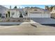 Charming single-story home featuring a three-car garage, desert landscaping, and a classic tile roof at 2221 Loggerhead Rd, Las Vegas, NV 89117