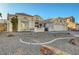 A single-story home with a three-car garage and minimalist landscaping featuring a drought-tolerant design at 2221 Loggerhead Rd, Las Vegas, NV 89117