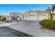 A single-story home showcases a three-car garage, concrete driveway, and xeriscaping for low maintenance at 2221 Loggerhead Rd, Las Vegas, NV 89117