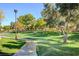 Community green space with lush lawns, mature trees, and meandering sidewalk perfect for strolls at 2221 Loggerhead Rd, Las Vegas, NV 89117