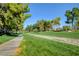 Serene community walking path, lined with mature trees and lush landscaping at 2221 Loggerhead Rd, Las Vegas, NV 89117
