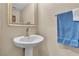 Neutral-toned bathroom features a pedestal sink, a mirror, and towel bar at 2376 Via Firenze, Henderson, NV 89044