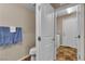 Bright half bathroom features a commode, an open doorway to laundry, and towel bars at 2376 Via Firenze, Henderson, NV 89044