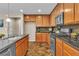 Updated kitchen showcasing stainless steel appliances, granite counters, and wood cabinets at 2376 Via Firenze, Henderson, NV 89044