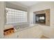Bathroom featuring large soaking tub with fireplace and decorative statue by window at 2705 Crystal Beach Dr, Las Vegas, NV 89128