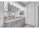Bright bathroom featuring a double vanity with granite counters and decorative mirrors at 2705 Crystal Beach Dr, Las Vegas, NV 89128