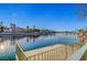 Wooden dock with metal railing provides serene views of the calm lake and waterfront residences at 2705 Crystal Beach Dr, Las Vegas, NV 89128