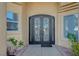 Elegant wrought iron double front doors add curb appeal to this home with a tiled walkway at 2705 Crystal Beach Dr, Las Vegas, NV 89128