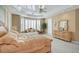 Spacious main bedroom featuring tray ceiling, sitting area, and natural light from shuttered windows at 2705 Crystal Beach Dr, Las Vegas, NV 89128