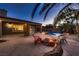 The inviting backyard features a cozy fire pit, pool with waterfall, and lush landscaping at 2764 Kilwinning Dr, Henderson, NV 89044