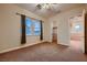 Neutral bedroom featuring a ceiling fan, carpet, windows, and an attached closet for convenient storage at 2764 Kilwinning Dr, Henderson, NV 89044