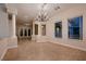 Elegant living room with neutral tones, tile flooring, chandelier, and lots of natural light at 2764 Kilwinning Dr, Henderson, NV 89044