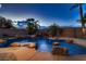 Beautiful pool featuring rock accents and lush palm trees, creating a private tropical oasis at 2764 Kilwinning Dr, Henderson, NV 89044