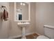 Bathroom featuring a pedestal sink, a framed mirror, tile floors and a toilet at 2764 Kilwinning Dr, Henderson, NV 89044