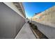 Narrow side yard features a concrete walkway and a well-maintained concrete block wall at 2914 Luminous Ct, North Las Vegas, NV 89032