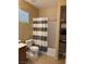 Bright bathroom with shower-tub combo, large mirror, and ample storage shelves perfect for organization at 3609 Citrus Heights Ave, North Las Vegas, NV 89081
