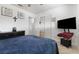 Well-lit bedroom with neutral walls, tv mounted on the wall and a blue comforter on the bed at 4431 Bennett Dr, Las Vegas, NV 89121