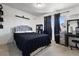 Bedroom with a black comforter on the bed, dark curtains, and a vanity with a mirror at 4431 Bennett Dr, Las Vegas, NV 89121