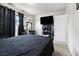 Spacious bedroom featuring a black comforter on the bed, dark curtains, and a tv at 4431 Bennett Dr, Las Vegas, NV 89121