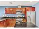 Modern kitchen equipped with stainless steel appliances, cherry wood cabinets, and dark countertops, designed for convenience at 4575 Dean Martin Dr # 1811, Las Vegas, NV 89103