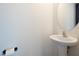 Half bath features a sleek pedestal sink, faucet, mirror, and toilet paper holder at 4941 Quest Tribe St, Las Vegas, NV 89122