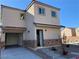 Two-story home with a two-car garage, stone accents, and desert landscaping provides a modern exterior design at 4941 Quest Tribe St, Las Vegas, NV 89122