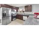 Well-lit kitchen features stainless appliances, modern cabinetry, granite counters, and wood-look flooring at 4941 Quest Tribe St, Las Vegas, NV 89122