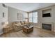 Comfortable living room with a fireplace, wood floors, a large window, and neutral tones at 5855 Valley Dr # 2108, North Las Vegas, NV 89031