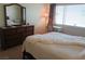 Sunlit bedroom features a dresser, a desk, and curtains framing the window at 6412 Big Pine Way, Las Vegas, NV 89108