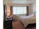 Sunlit bedroom features a comfy bed, a desk, and curtains framing a window at 6412 Big Pine Way, Las Vegas, NV 89108