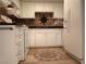 Cozy kitchen features white appliances and cabinets with a decorative backsplash and unique floor tile design at 6412 Big Pine Way, Las Vegas, NV 89108