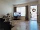 Bright living room with tile floors, a large window, and secure front door at 6412 Big Pine Way, Las Vegas, NV 89108