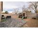 Private backyard with a brick patio, green hose, dark seating, playhouse, and sturdy fence at 652 Carlos Julio Ave, North Las Vegas, NV 89031