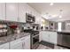 Open kitchen with granite countertops, stainless steel appliances, and island with sink at 652 Carlos Julio Ave, North Las Vegas, NV 89031