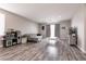 Bright living room features wood floors, a grey sofa, and lots of natural light from the sliding glass door at 652 Carlos Julio Ave, North Las Vegas, NV 89031