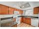 Well-lit kitchen featuring wood cabinets, granite countertops and white appliances at 7300 Pirates Cove Rd # 2087, Las Vegas, NV 89145