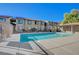 Community pool with ample lounge space, surrounded by the building and lush landscaping under a clear blue sky at 7300 Pirates Cove Rd # 2087, Las Vegas, NV 89145