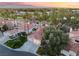 An aerial view of the neighborhood with lush trees and golf course, showcasing the house's roof tiles at 7608 Painted Dunes Dr, Las Vegas, NV 89149