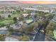 Picturesque aerial view showcases a golf course, tennis courts, and the community's lush desert landscaping at 7608 Painted Dunes Dr, Las Vegas, NV 89149