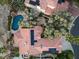 An aerial view shows the backyard pool and desert landscaping with red tile roof and solar panels at 7608 Painted Dunes Dr, Las Vegas, NV 89149