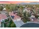 An aerial view showcasing mature trees, a home's tile roof, and a three car garage at 7608 Painted Dunes Dr, Las Vegas, NV 89149