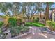 Backyard featuring a charming pond, mature trees, and rock landscaping at 7608 Painted Dunes Dr, Las Vegas, NV 89149