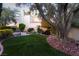 An outdoor patio features a koi pond, lush artificial lawn, and desert landscaping at 7608 Painted Dunes Dr, Las Vegas, NV 89149