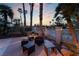 Backyard featuring a cozy fire pit area with seating, a perfect spot for outdoor gatherings surrounded by palm trees at 7608 Painted Dunes Dr, Las Vegas, NV 89149
