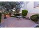 A private outdoor patio area featuring a table, bench, and well-manicured landscaping at 7608 Painted Dunes Dr, Las Vegas, NV 89149