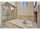 Luxurious bathroom with a large soaking tub, a separate glass shower, and elegant tile accents at 7608 Painted Dunes Dr, Las Vegas, NV 89149
