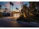 Well-maintained home features a three-car garage, lush landscaping, and a welcoming curb appeal at dusk at 7608 Painted Dunes Dr, Las Vegas, NV 89149
