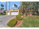 Charming home features a two-car garage, beautiful landscaping, and well-maintained lawn at 7608 Painted Dunes Dr, Las Vegas, NV 89149