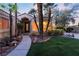 A charming front entrance featuring well-manicured landscaping, a green lawn and large bay window at 7608 Painted Dunes Dr, Las Vegas, NV 89149