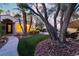 A beautiful front yard with mature trees, manicured lawn and landscape lighting and a pond at 7608 Painted Dunes Dr, Las Vegas, NV 89149